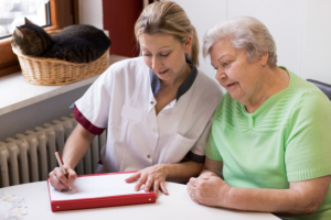 caregiver helipng her patient making a letter