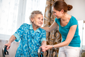 caregiver assisting her patient in walking